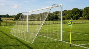 Fußballtor mit gespanntem Netz und Eckfahne auf einem leeren Spielfeld
